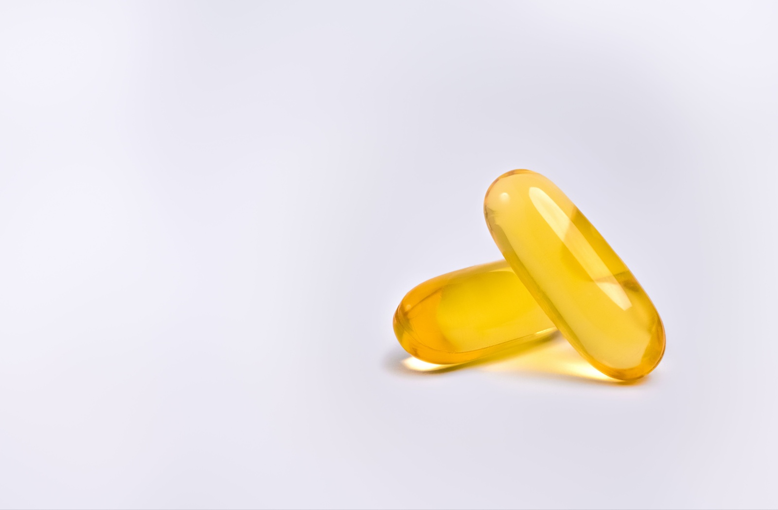 A close-up photo of two Omega-3 fish oil capsule supplements, which help support eye and overall health